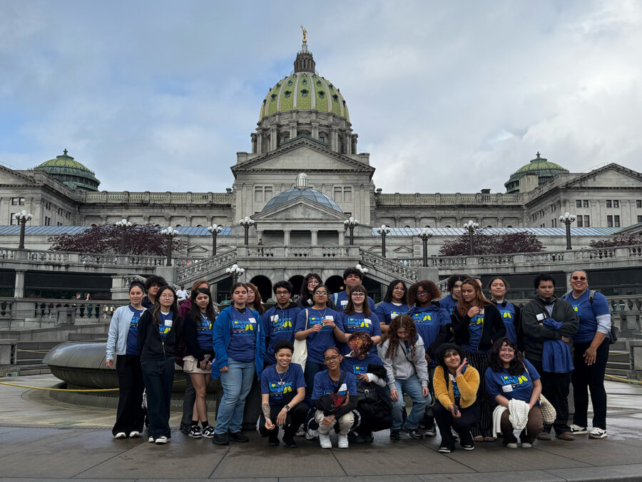 Group of people standing gin front of Harrisburg PA's Capitol.